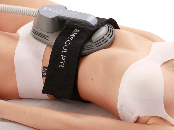 EMS Body Contouring machine applied to a client’s waist, utilizing muscle stimulation for toning.